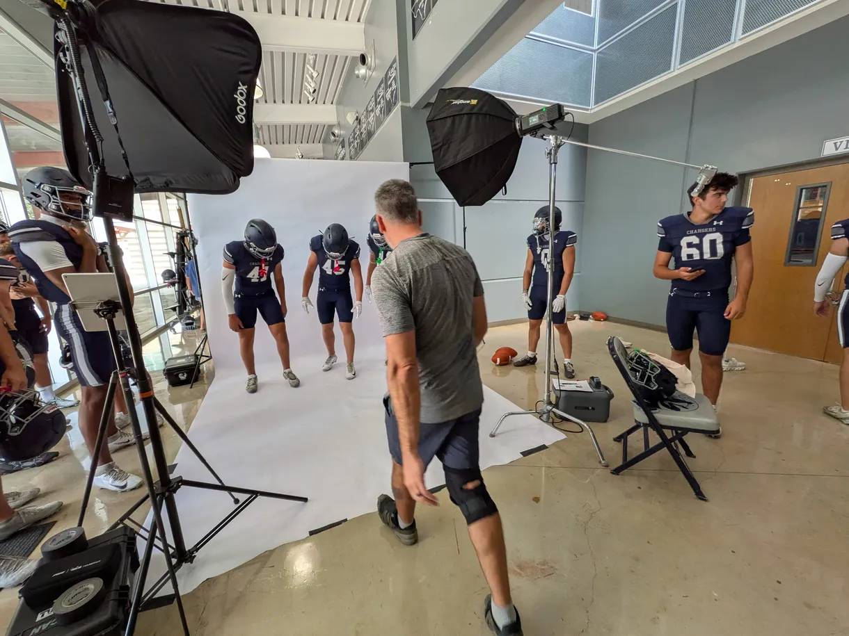 Football athletes at an on-site media-day studio with lit backdrops