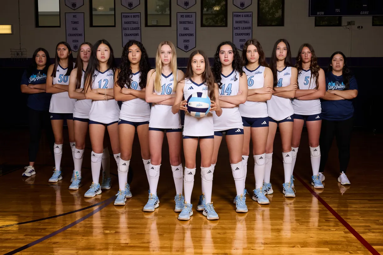 Full volleyball team lined up for their media-day photo in the gym