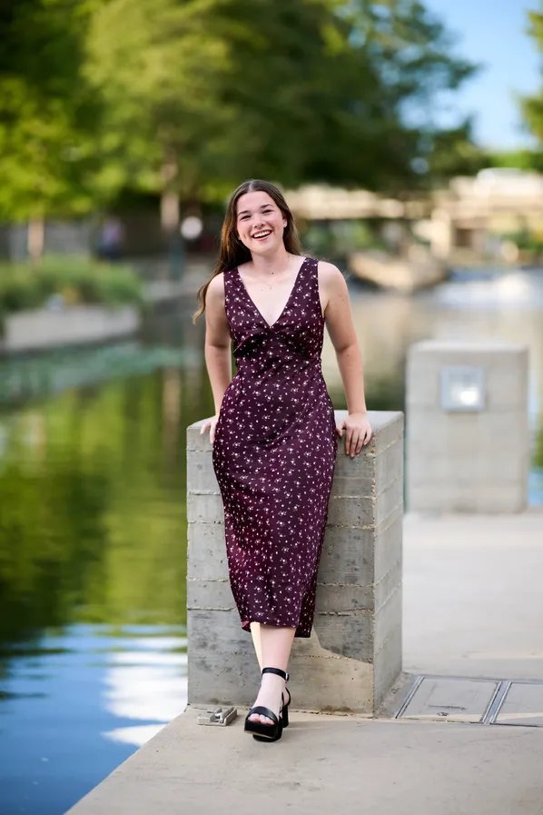 Senior portrait beside the river walk in evening light